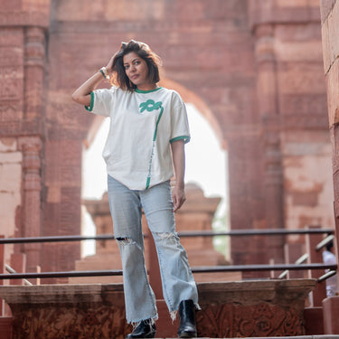 Woman standing in front of historical architecture with arches and columns.